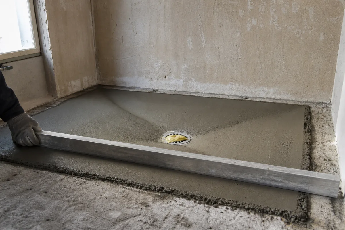 Douche à l&rsquo;italienne de plain-pied avec paroi de verre dans une salle d&rsquo;eau claire