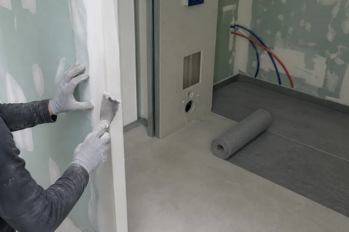 Salle de bains en cours de rénovation, cloison hydrofuge posée et sol préparé avant carrelage